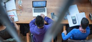 Aerial view of students studying and working on laptops at a communal desk